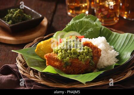 Ayam Geprek Andaliman. Fusion Street Food Gericht der Southern Fried Chicken gekrönt mit Sambal Andaliman, die grüne Chili und Andaliman Pfeffersoße. Stockfoto