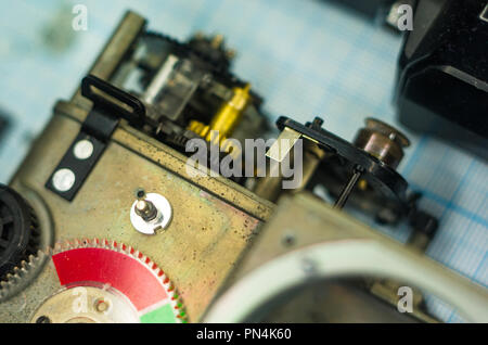 Teile sind vollständig demontiert alten retro Film SLR Kamera auf Millimeterpapier, close-up Stockfoto