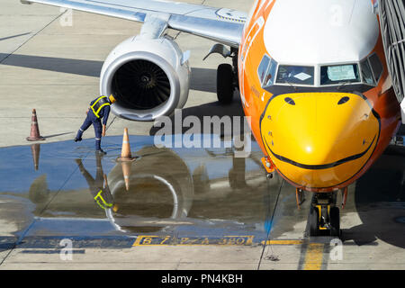 Bangkok, Thailand - 19. September 2018: Die bodenmannschaft Arbeiter Kontrolle Flugzeug Turbine Engine, Luftansaug- und Lüfterflügel des Nok Air Flugzeug. Stockfoto