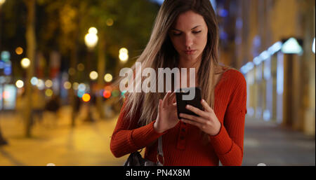 Junge Dame Smartphone aus der Tasche zu Text auf Champs-Elysees zu antworten Stockfoto