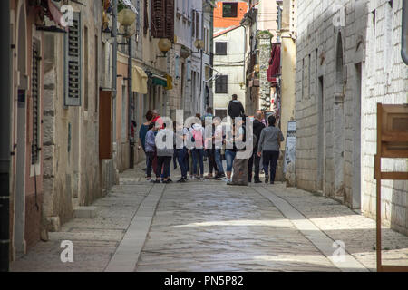 Istrien, Kroatien, April 2018 - Touristen und Einheimische auf der Straße mit Kopfsteinpflaster in der Altstadt von Porec Stockfoto