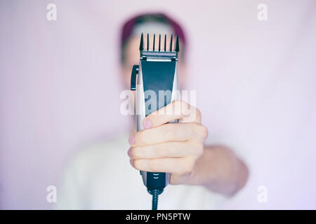 Junge männliche Hipster hält Rasierapparat isoliert Stockfoto