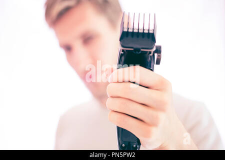 Junge männliche Hipster hält Rasierapparat isoliert Stockfoto