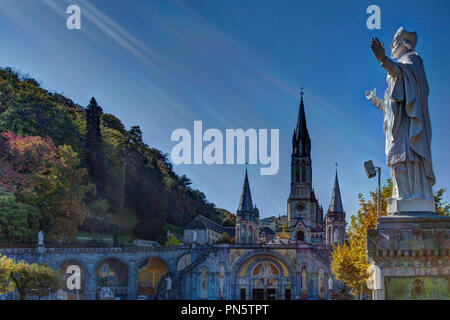 Lourdes (Frankreich): äußere Ansicht der Basilika Unserer Lieben Frau vom Rosenkranz, den Platz und Unsere Liebe Frau von Lourdes Sanctuary. Sonnenstrahlen auf der St Stockfoto