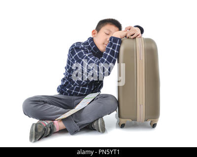 Asian Boy schlafen mit Karte und Gepäck auf weißem Hintergrund. Stockfoto