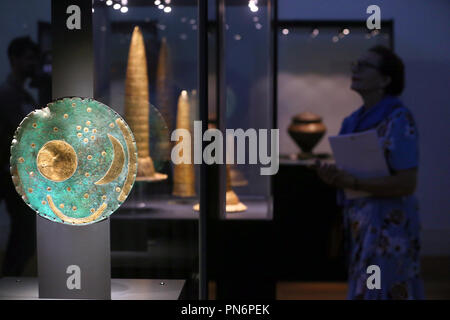 20. September 2018, Berlin: ein Besucher der Ausstellung 'bewegte Zeiten. Archäologie in Deutschland "die Himmelsscheibe von Nebra, die in einer Glasvitrine steht geschützt. Im Hintergrund gold Hüte aus der Bronzezeit. Die spektakulären Funde der letzten 20 Jahre aus ganz Deutschland gezeigt. Mehr als 1000 Exponate aus allen deutschen Staaten, von der Himmelsscheibe von Nebra zu den antiken Hafen Mauer des römischen Köln, vorgestellt werden. Foto: Wolfgang Kumm/dpa Stockfoto