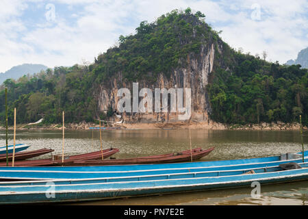 Angelegte Boote am Mekong Fluss vor einem Kalkstein Klippe, wo die berühmten Höhlen von Pak Ou eingestellt sind. Sie sind in der Nähe von Luang Prabang in Laos. Stockfoto