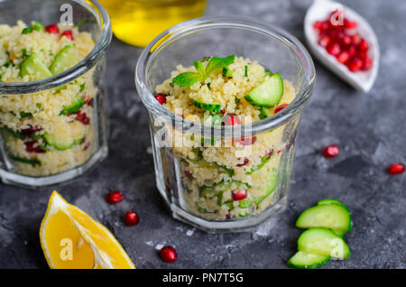Couscous Salat in einem Glas mit Granatapfel, Minze und Gurken, gesunde Hausmannskost, vegane Mahlzeit Stockfoto