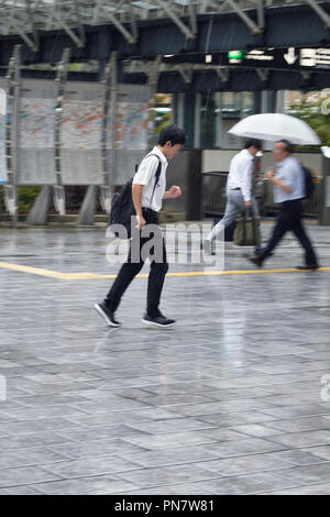 Japanische Schüler im Regen laufen Stockfoto