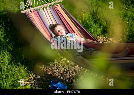 Ein kleiner Junge in einer Hängematte liegend. Stockfoto