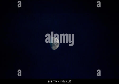 Whispers of the Moon: Eine himmlische Serenade, die im ätherischen Glanz des Halbmondes getaucht ist, entfaltet der Nachthimmel eine Geschichte des kosmischen Wunders. Stockfoto