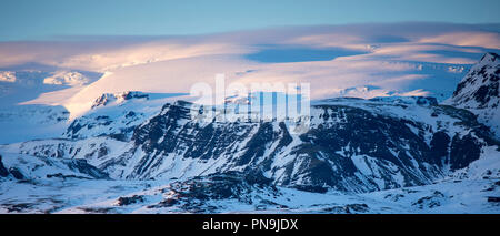 Winterliche Sonne über typisch isländischen verschneite Gebirge Gletscher Landschaft im Süden Islands Stockfoto