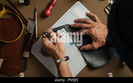 Der Prozess der Herstellung von handgefertigten Lederetui in das Leder Werkstatt. Stockfoto