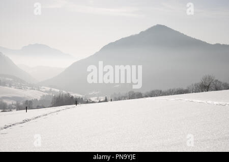 Snowy hintergrundbeleuchtete Berglandschaft in den französischen Alpen. Stockfoto