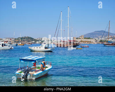 Bodrum, Türkei - Juli 5, 2018. Boote bei Kumbahce Bucht mit dem Schloss von St. Peter im Hintergrund. Provinz Mugla, Türkei. Stockfoto