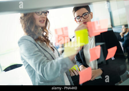 Business Leute, die im Büro und Post-it Notizen Idee zu teilen Stockfoto