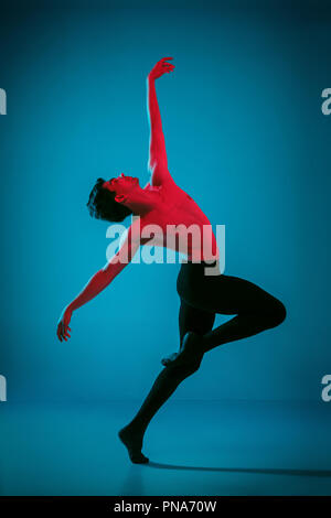 Die männlichen athletischen Ballet Dancer performing Tanz am strahlend blauen Hintergrund. Studio gedreht. Modernes Ballett, modernen Konzept. Fit jungen Mann. Kaukasische Modell Stockfoto