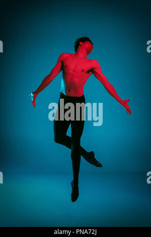 Die männlichen athletischen Ballet Dancer performing Tanz am strahlend blauen Hintergrund. Studio gedreht. Modernes Ballett, modernen Konzept. Fit jungen Mann. Kaukasische Modell Stockfoto