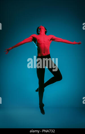 Die männlichen athletischen Ballet Dancer performing Tanz am strahlend blauen Hintergrund. Studio gedreht. Modernes Ballett, modernen Konzept. Fit jungen Mann. Kaukasische Modell Stockfoto