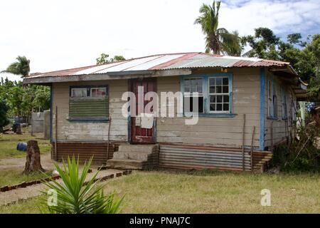 Ein Haus mit einem Wellblechdach innerhalb einer Tongan Village auf der Insel Atata, Königreich Tonga Stockfoto