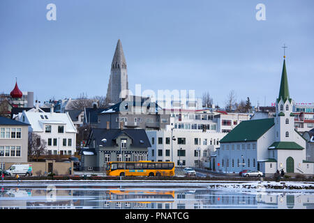 Gelben Bus - Reisebus - in der Hauptstadt Reykjavik und der Lutherischen Kirche Hallgr bin skirkja Kathedrale, Island Stockfoto