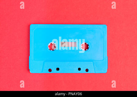 Retro blau Audio Cassette auf rotem Papier Hintergrund Stockfoto