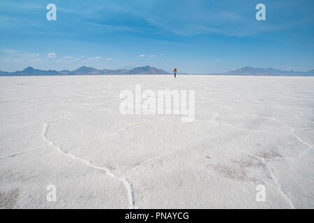 Eine blonde Frau geht über Bonneville Salt Flats, Tooele County, Utah, USA. Stockfoto