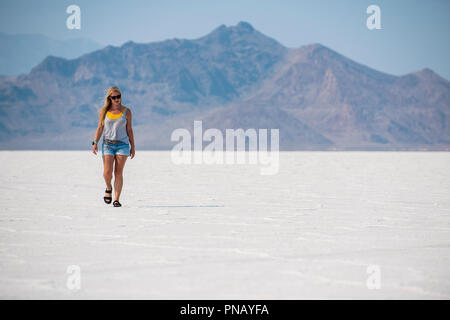 Eine blonde Frau geht über Bonneville Salt Flats, Tooele County, Utah, USA. Stockfoto