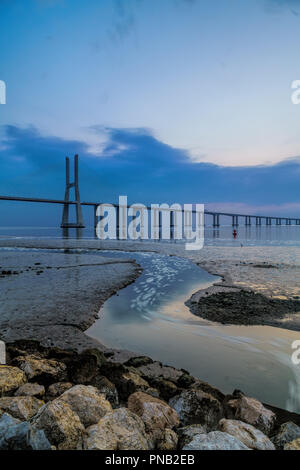 Amazing sunrise in der Vasco da Gama Brücke in Lissabon. Landschaft einer der Hauptattraktionen von Portugal, eine der längsten Brücken der Welt. Stockfoto