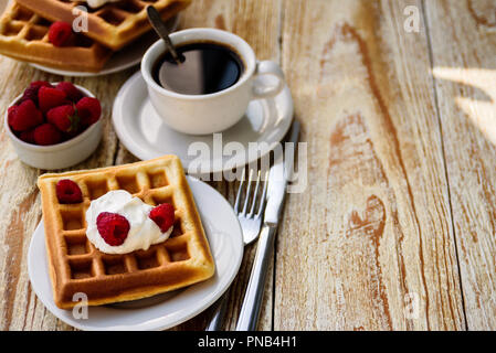 Belgische Waffeln mit Himbeeren und Sahne zum Frühstück Stockfoto