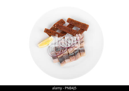 Snack, Croutons aus schwarzem, Roggen, Brot, Hering, Fisch leicht gesalzen, Zwiebel, Zitronenscheibe, Aperitif vor dem Alkohol auf Platte, weiß isoliert Hintergrund Stockfoto