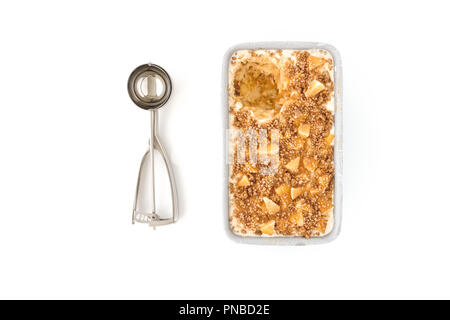 Hausgemachte Toffee Apple Eis in einem Metallbehälter und einen Eisportionierer auf weißem Hintergrund. Stockfoto