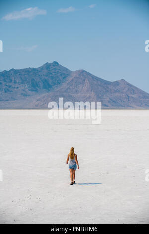 Eine blonde Frau geht über Bonneville Salt Flats, Tooele County, Utah, USA. Stockfoto