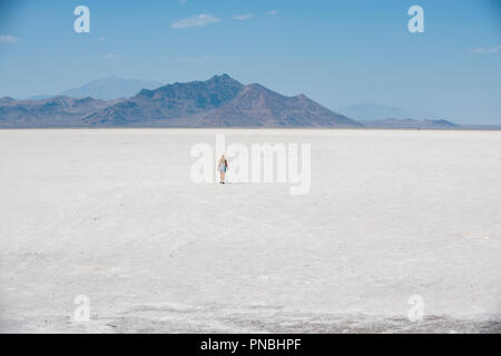 Eine blonde Frau geht über Bonneville Salt Flats, Tooele County, Utah, USA. Stockfoto