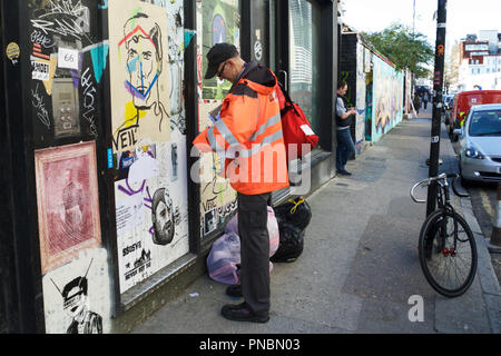 Royal Mail Postbote Zustellung von Mails in Shoreditch, East London, UK. Stockfoto