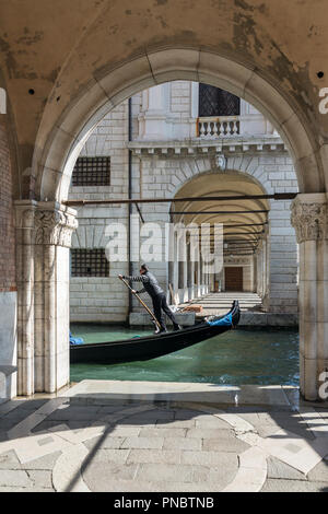 Venedig, Italien, 21. März 2018: Venezianische Gondoliere reiten Gondel durch die seitlichen schmalen Kanal in Venedig. Stockfoto