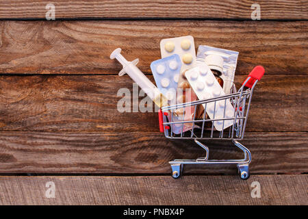 Warenkorb mit Pillen, die Spritze auf dem alten Holz Hintergrund. Getönten Bild. Stockfoto