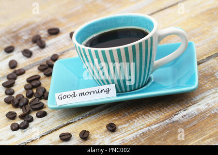 Guten Morgen Karte mit Tasse Kaffee und Kaffeebohnen auf Holzmöbeln im Landhausstil Oberfläche Stockfoto