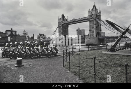 Eine Gruppenaufnahme von London Polizei Motorradfahrer vor der Tower Bridge, London, England, UK. Ca. 80er Stockfoto