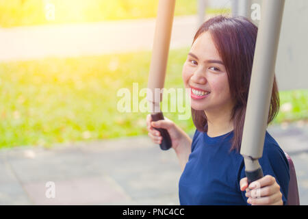 Jungen asiatischen Lächeln Brust Übung im Park für gesundes Genießen, Frauen Training Outdoor. Stockfoto