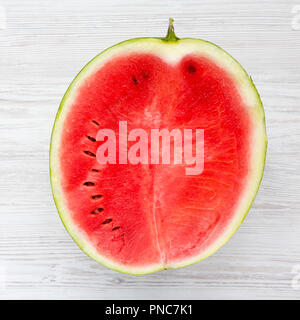 Die Hälfte geschnittenen Wassermelone auf weissem Holztisch. Close-up. Stockfoto