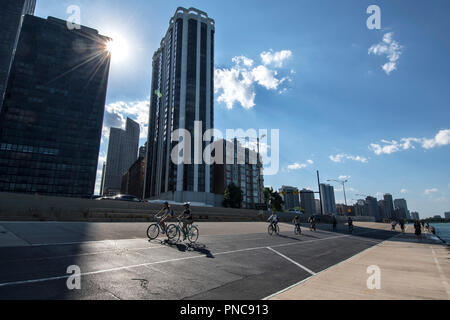 Fahrradfahrer und Fußgänger, direkt am Wanderweg auf dem Lake Shore Drive mit Blick auf die Skyline von Chicago, IL. Stockfoto