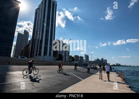 Fahrradfahrer und Fußgänger, direkt am Wanderweg auf dem Lake Shore Drive mit Blick auf die Skyline von Chicago, IL. Stockfoto