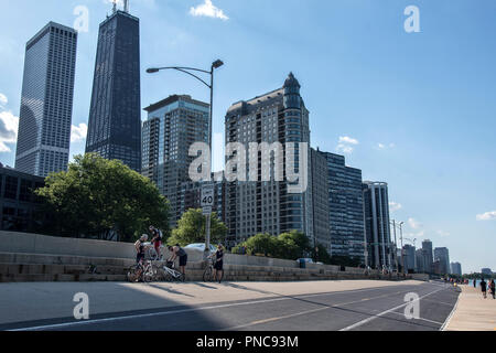 Radfahrer, direkt am Wanderweg auf dem Lake Shore Drive mit Blick auf die Skyline von Chicago, IL. Stockfoto