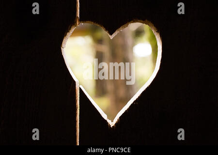 Herz carved in dunklem Holz Wand Textur, mit bokeh Hintergrund Stockfoto