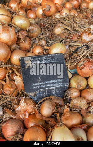 Frische Zwiebeln mit schiefertafel für Preis auf dem Markt. Reif Zwiebeln Hintergrund. Stockfoto
