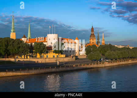 Riga Lettland Stadtbild, Sonnenuntergang Blick auf die Altstadt von Riga Schloss entlang des Flusses Daugava mit den Turmspitzen und Türme der mittelalterlichen Altstadt hinaus, Lettland. Stockfoto