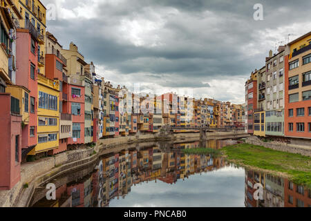 Bunte gelb, rot und orange Häuser mit der katalanischen Flaggen in Wasser Fluss Onyar, in Girona, Katalonien, Spanien wider. Stockfoto