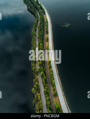 Straße auf einem schmalen Stück Land zwischen zwei Seen, mit Straßen und Eisenbahn, aus der Luft gesehen ridge Finnland Punkaharju Stockfoto