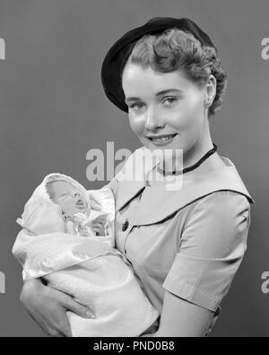 1950 Portrait lächelnden jungen Frau Mutter tragen BARETT HUT AUF KAMERA HOLDING BABY BABY SOHN IN DEN ARMEN-b 5169 HAR 001 HARS STÄDTISCHE MÜTTER ALTE ZEIT NOSTALGIE UMARMT ALTE MODE 1 JUVENILE STYLE junger Erwachsener KIND UMARMEN SÖHNE FREUEN FREUDE LIFESTYLE FEIER FRAUEN IM STUDIO SHOT GESUNDHEIT HOME LEBEN MIT HALBER LÄNGE HUG DAMEN PERSONEN PFLEGE MÄNNER UMARMEN B&W AUGENKONTAKT GLÜCK ENG HEITER LÄCHELT STOLZ IN VERBINDUNG FREUDIGE STILVOLLE BABY BOY BERET jugendliche Mütter Miteinander junger Erwachsener FRAU SCHWARZ UND WEISS KAUKASISCHEN ETHNIE HAR 001 ALTMODISCH Stockfoto